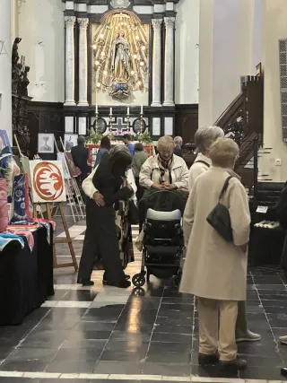 Visitors exploring the exhibition inside Sint-Denijskerk, with the church altar in the background